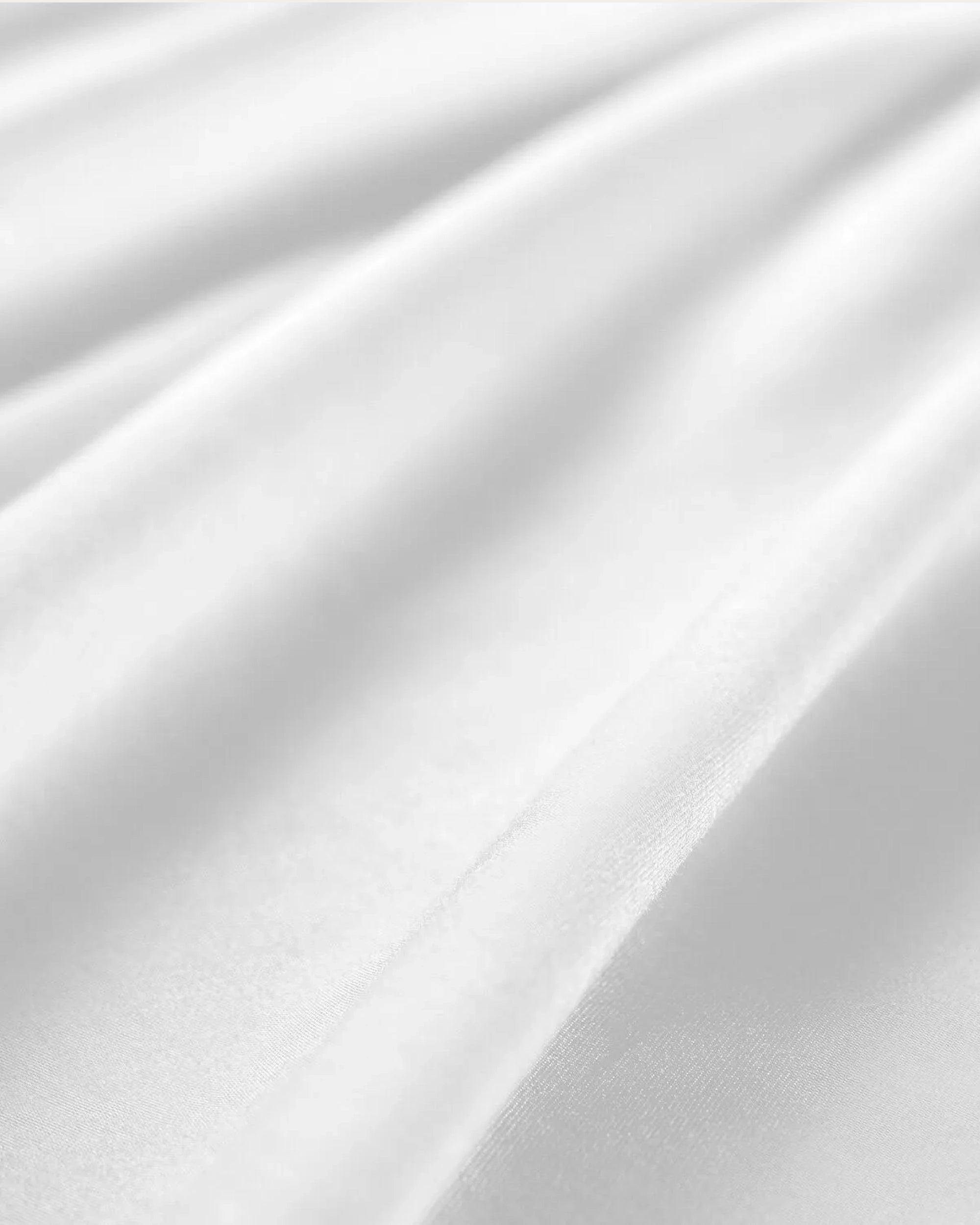 Close-up of frosted white satin fabric, showcasing its smooth texture ideal for pillowcases.