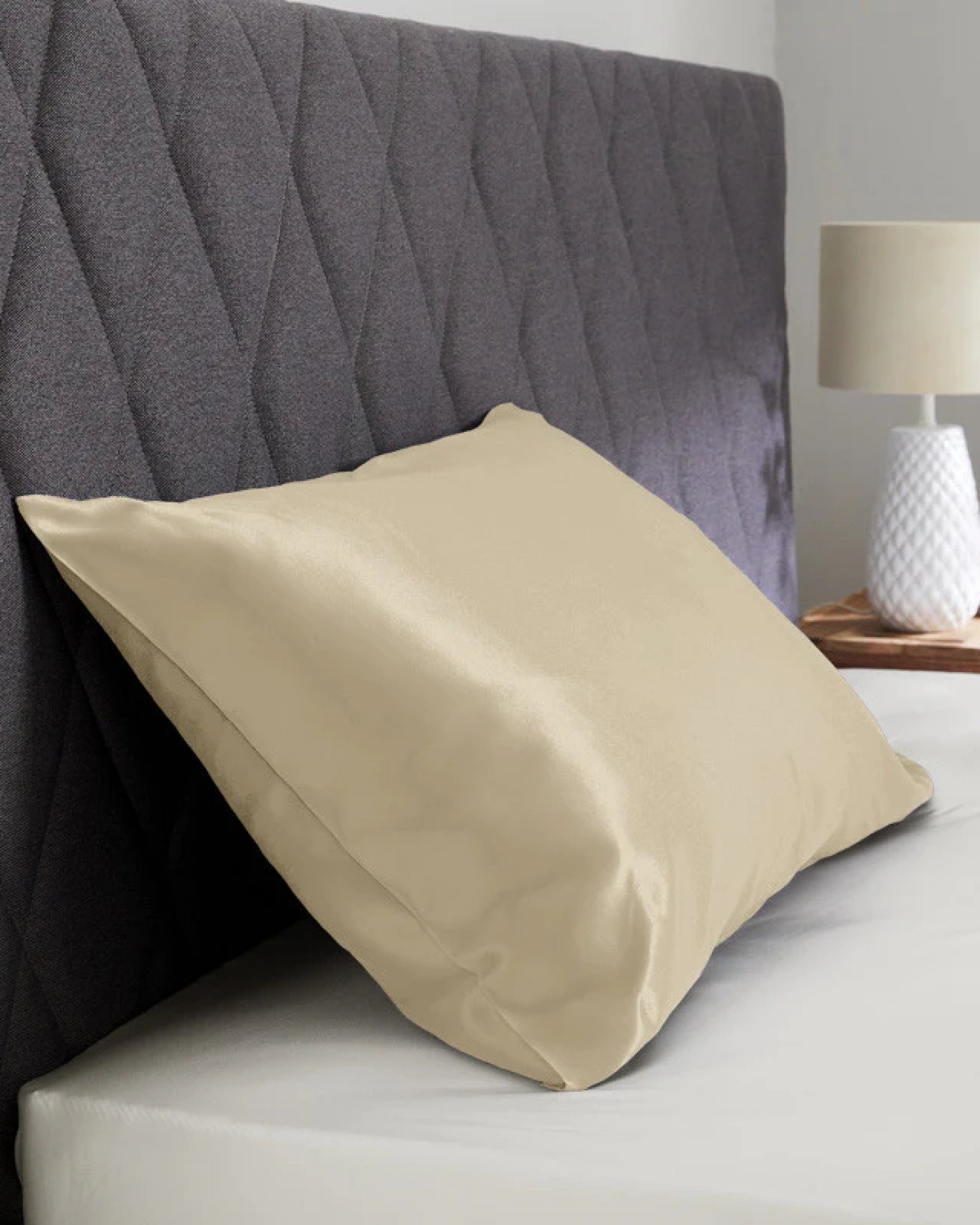 Beige satin pillowcase with a silky texture, perfect for enhancing bedroom decor and pampering hair and skin.