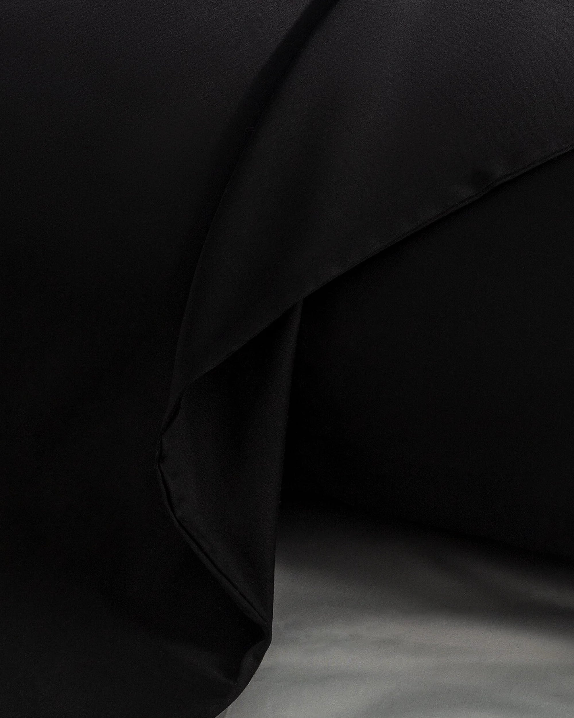 Close-up of a black velour satin pillowcase, showcasing its smooth texture and elegant design.