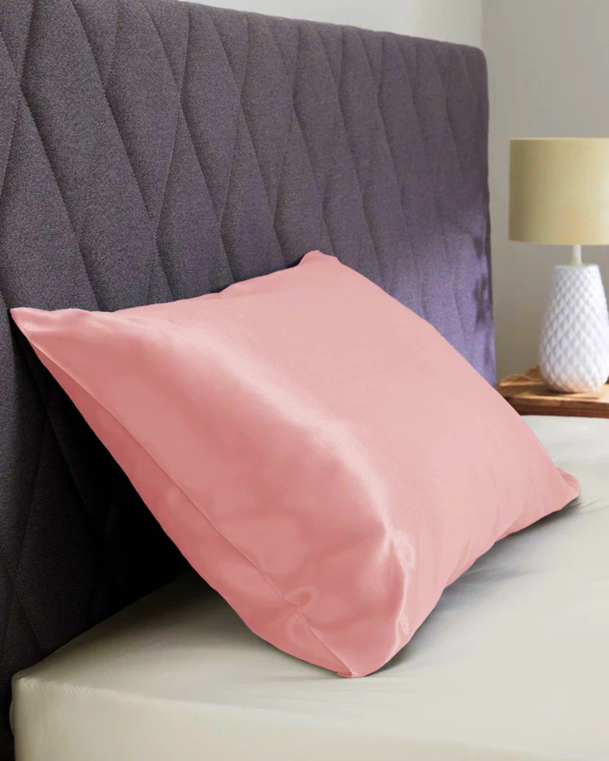 Blossom pink satin pillowcase on a bed, adding elegance and comfort to your bedroom decor.